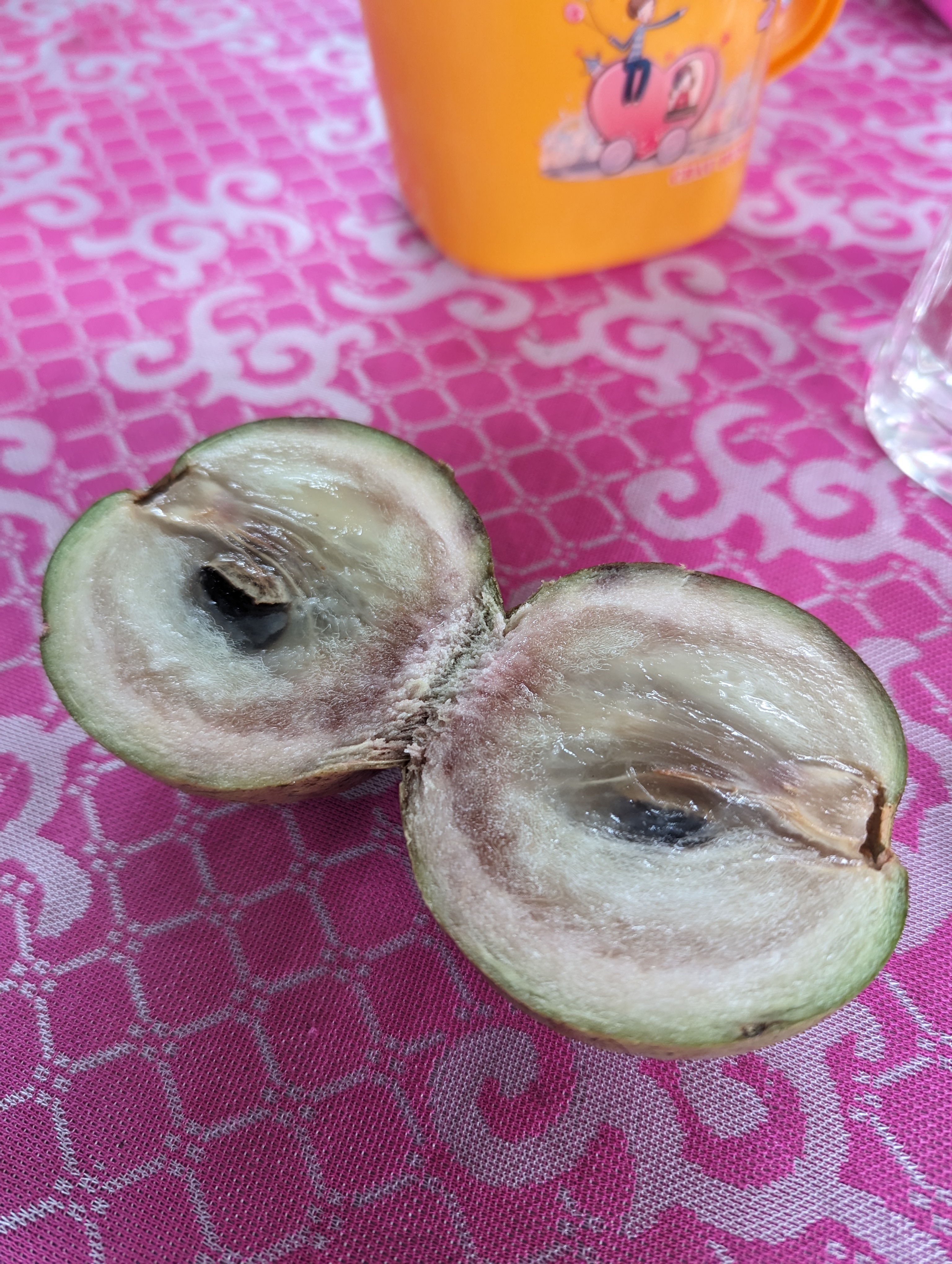 A star apple split open on a table in the south