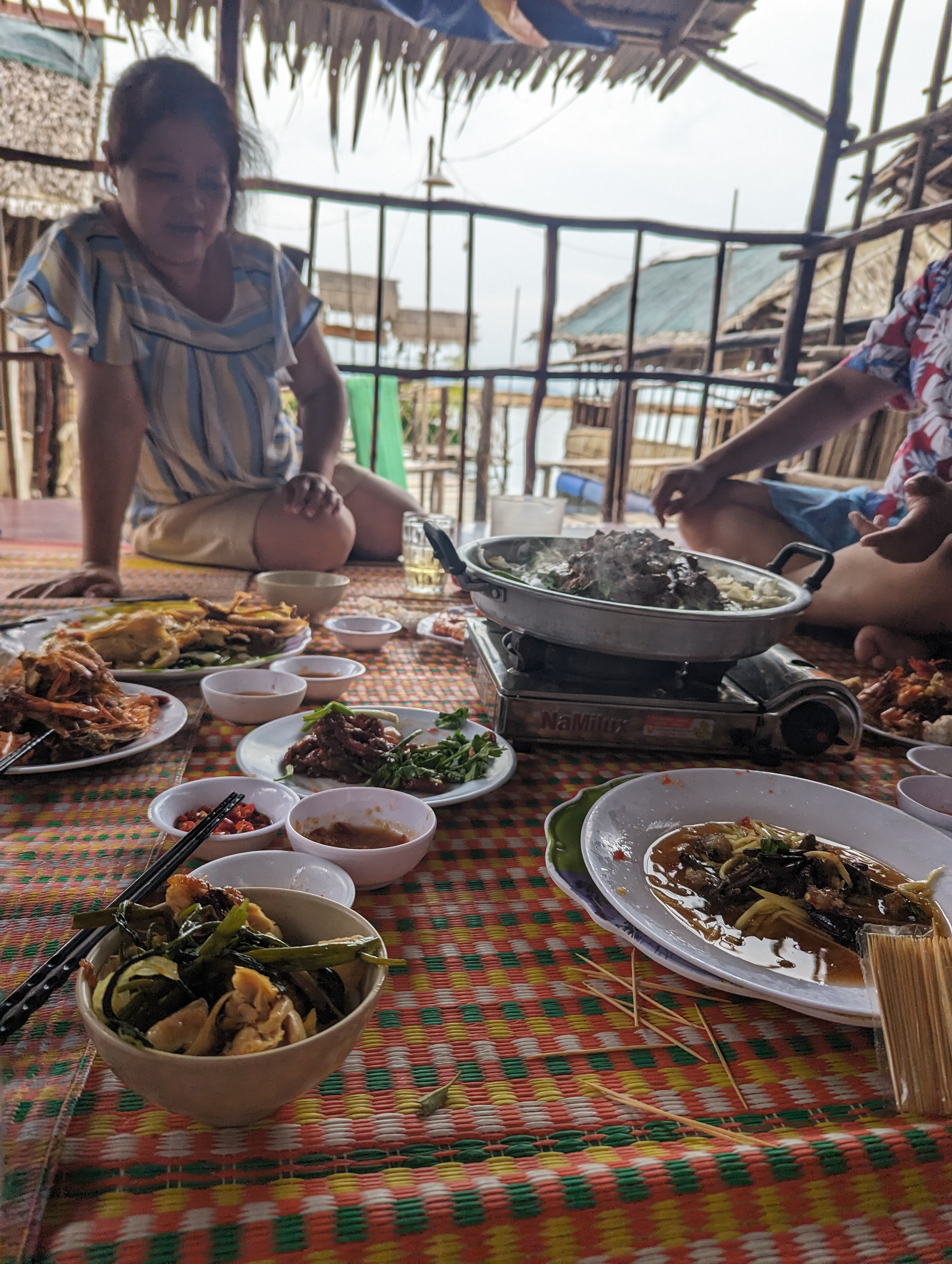A shared floor feast in a stilt house over the water