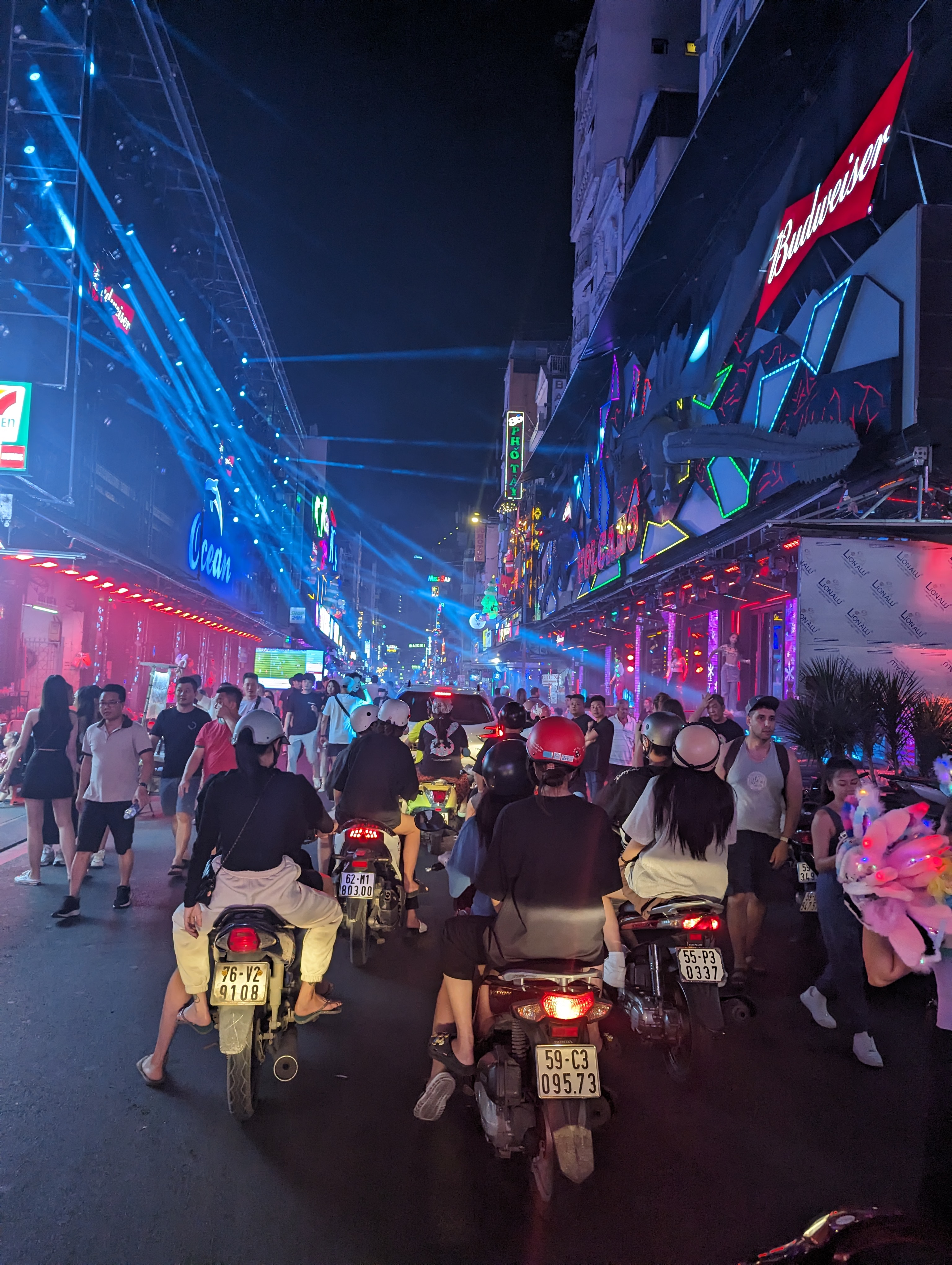 Neon and scooters on a busy street at night