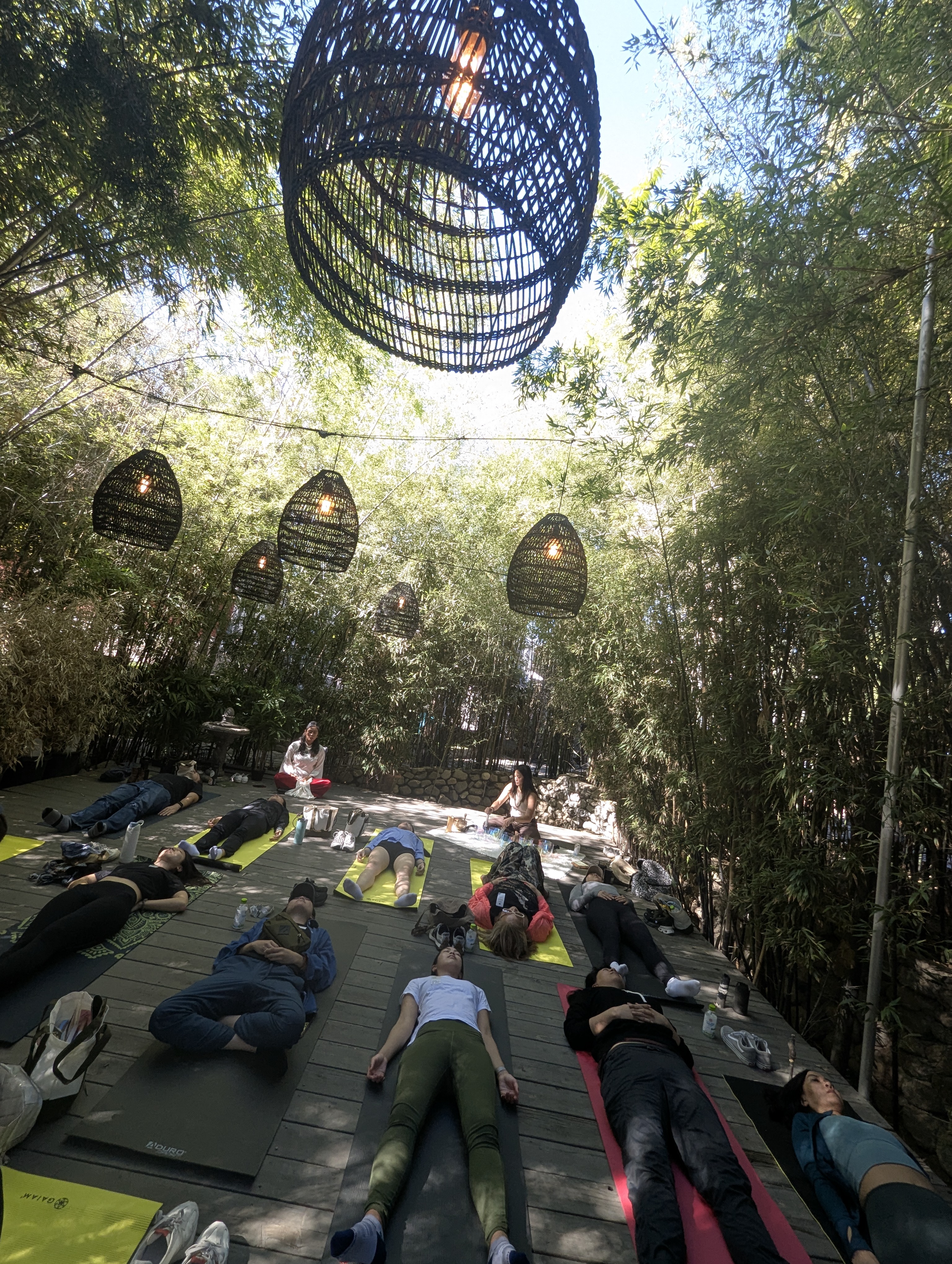 Outdoor sound bath under bamboo and woven lanterns