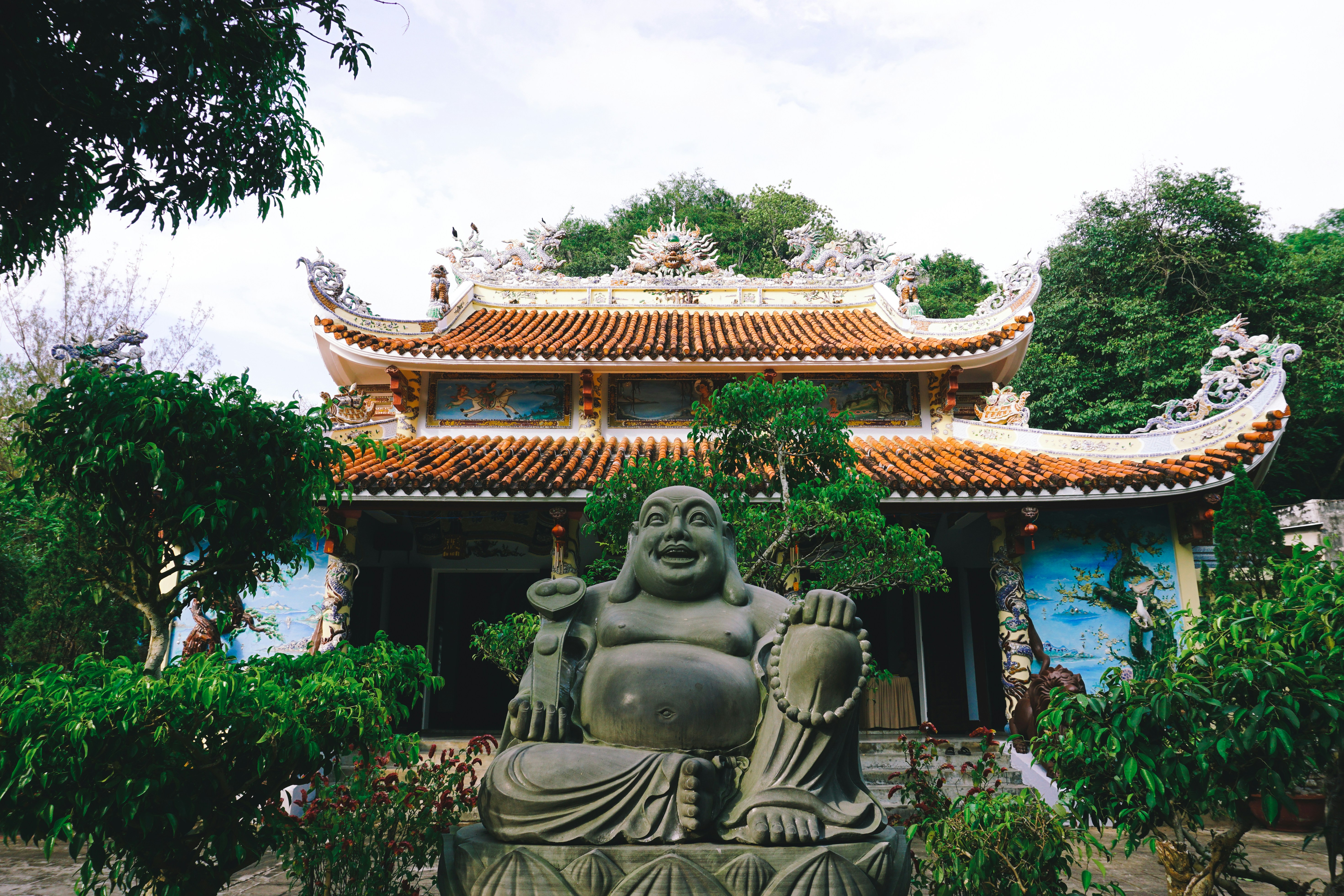 A tiled pagoda with a stone Buddha in its courtyard