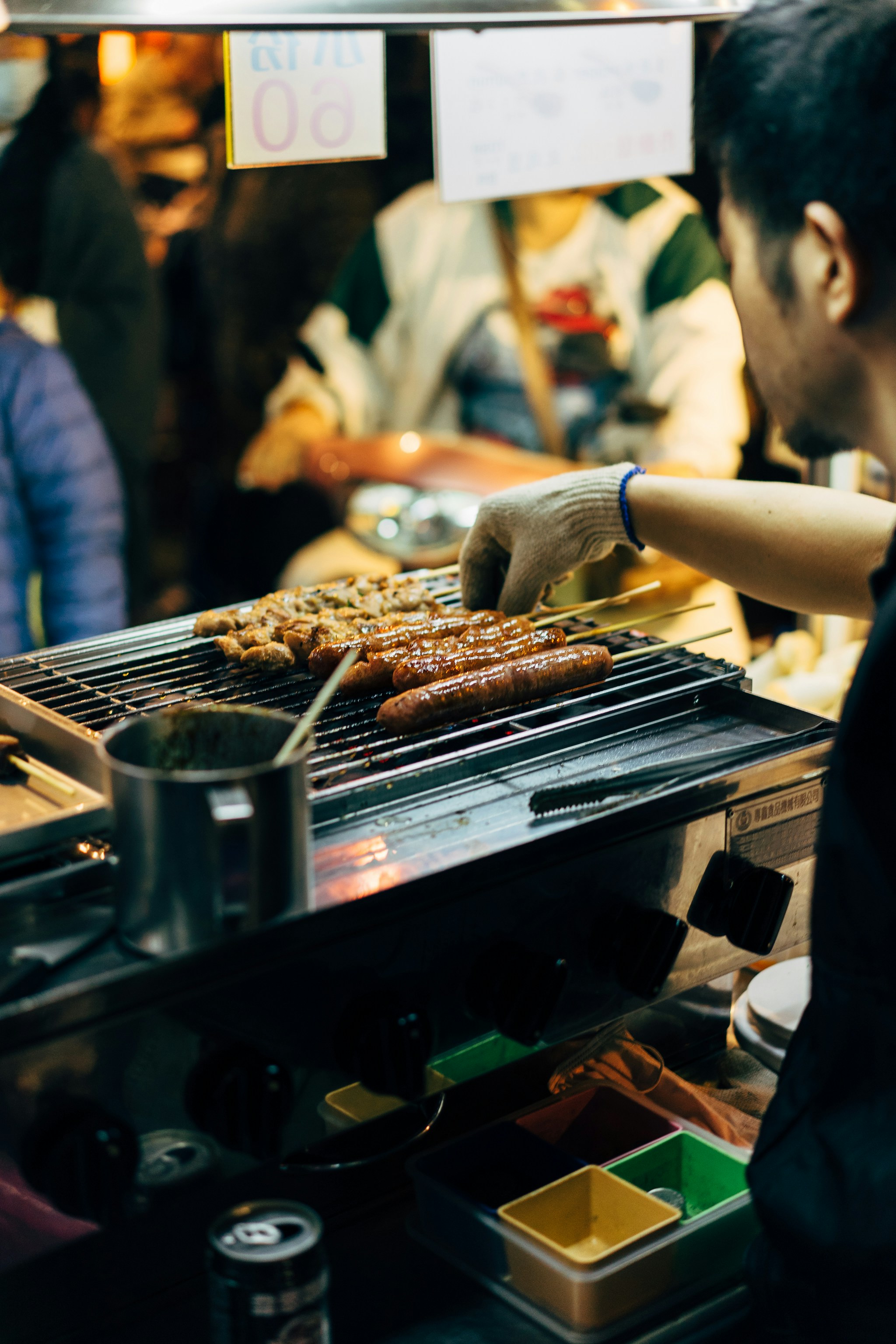 Skewers and sausages on a night market grill
