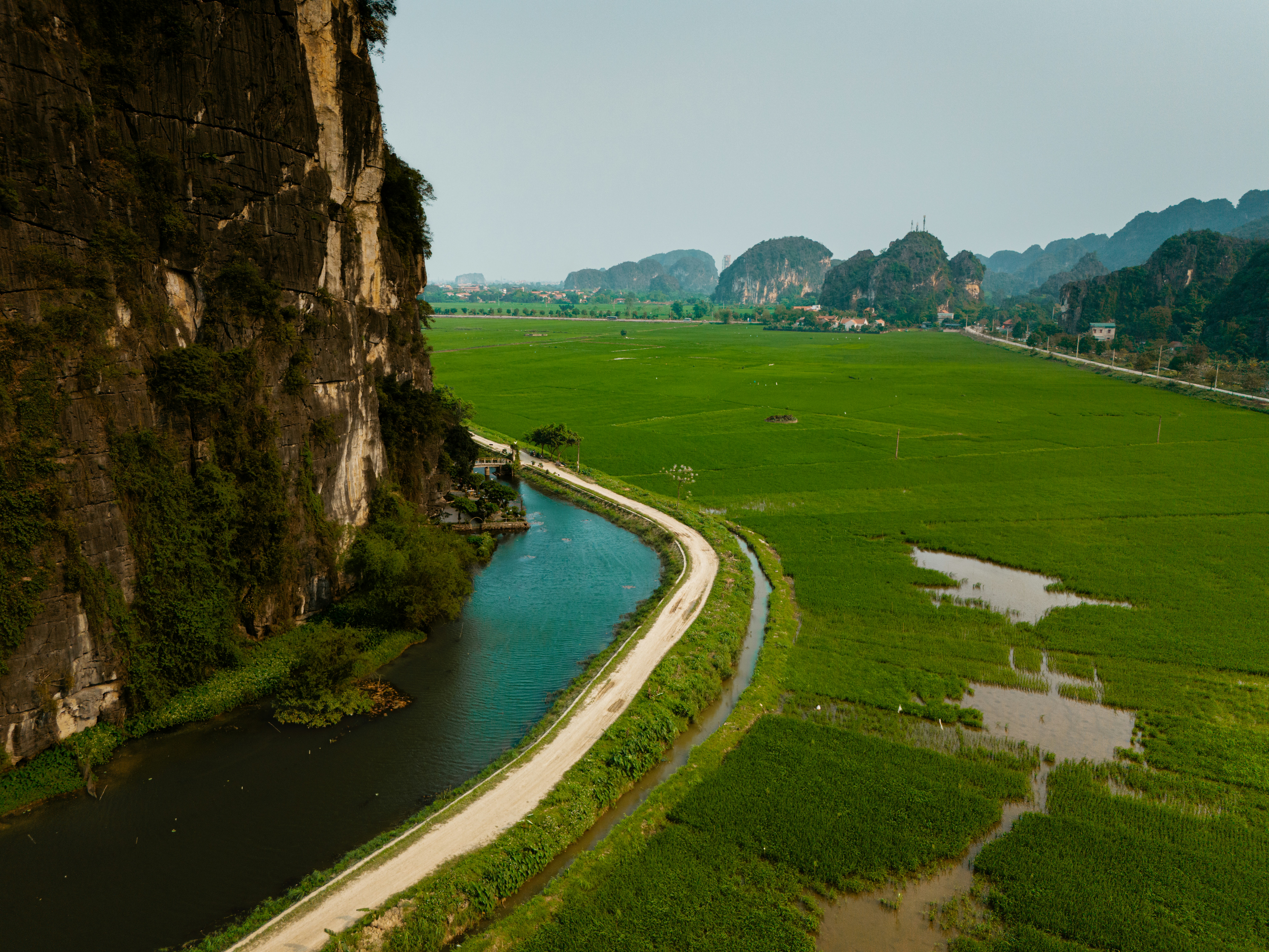 A river running past cliffs and rice fields