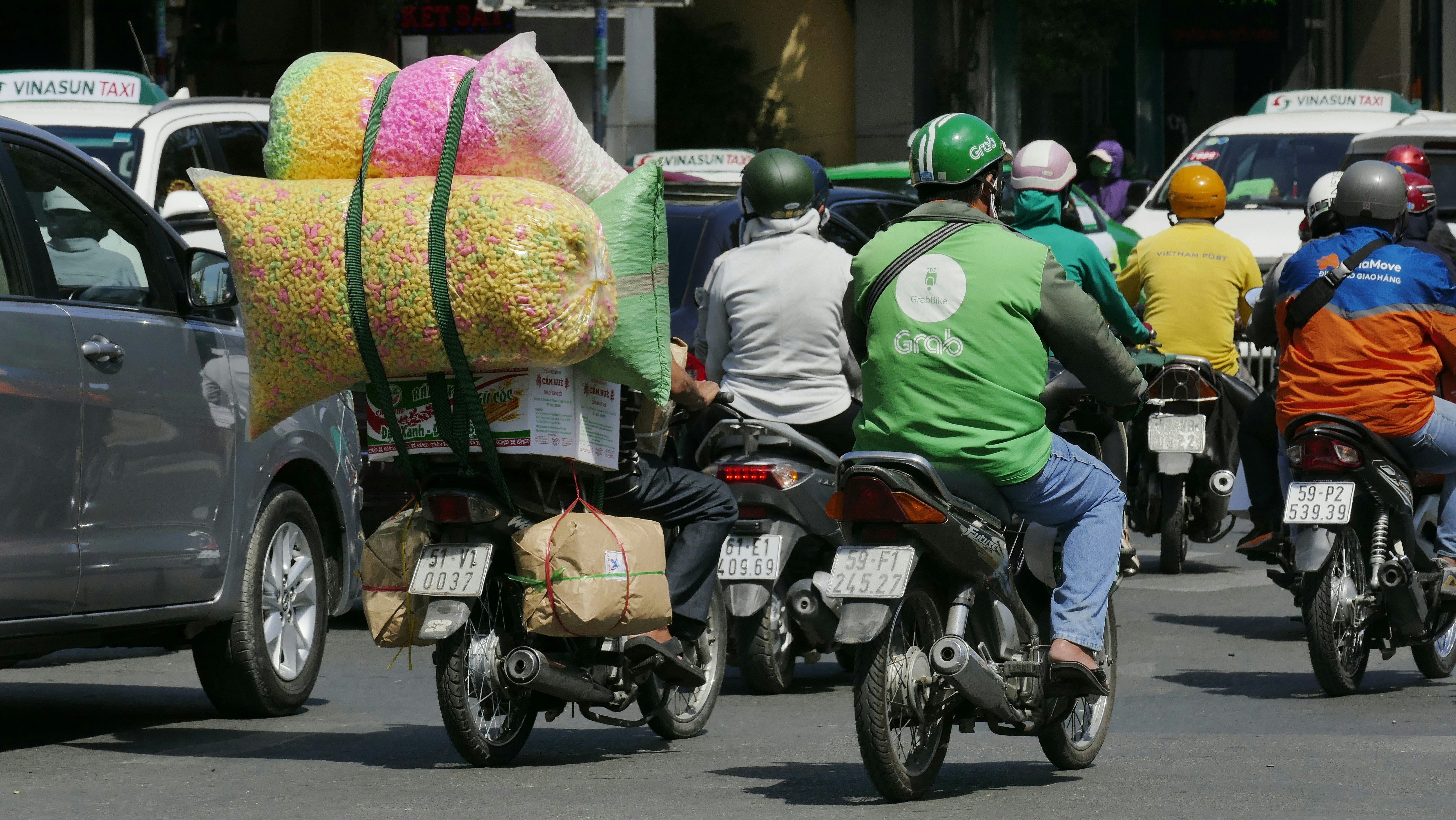 Motorbikes loaded with cargo in midday traffic